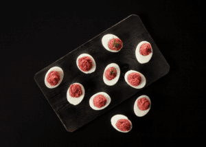 Beetroot an d Garlic Deviled Eggs plated and garnished with dill